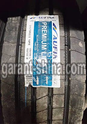 Aufine Premium Line A (рулевая) 315/70 R22.5 156/150L 18PR - Фото протектора с этикеткой вблизи